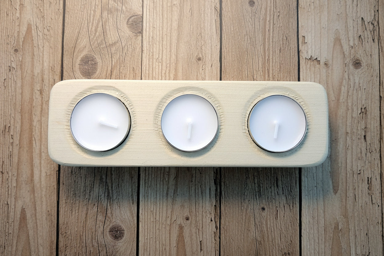 Wooden candle holder with three white candles on a rustic wood background