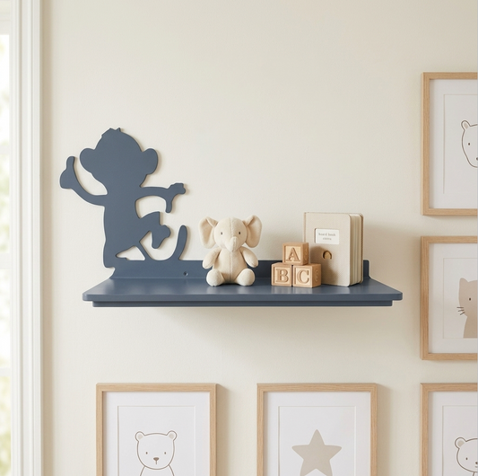 A grey wall-mounted shelf styled with a monkey silhouette, a small elephant plush, wooden alphabet blocks, and a small book, set against a warm cream wall with framed animal prints.
